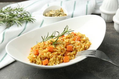 Photo of Delicious pumpkin risotto served on grey table, closeup