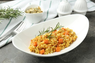 Photo of Delicious pumpkin risotto served on grey table, closeup