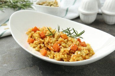 Photo of Delicious pumpkin risotto on grey table, closeup