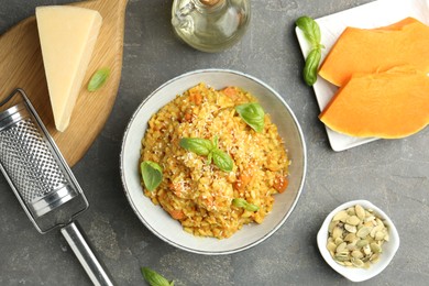 Photo of Delicious pumpkin risotto on grey table, flat lay