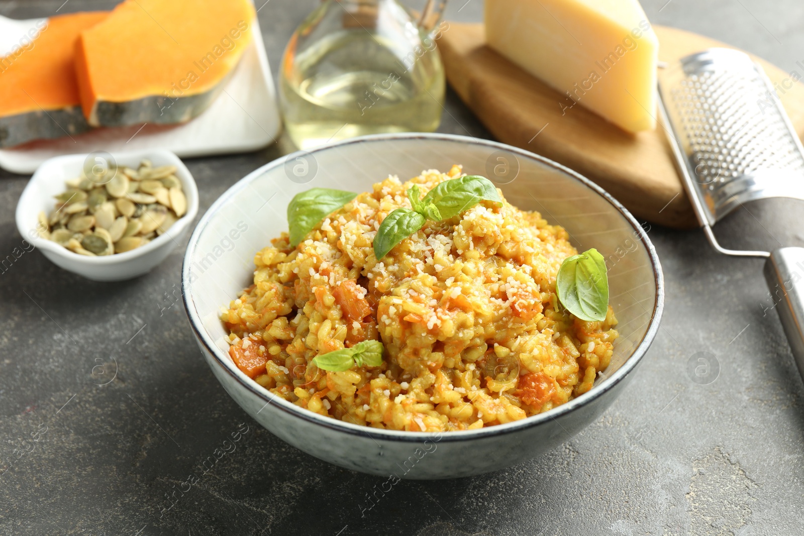 Photo of Delicious pumpkin risotto on grey table, closeup