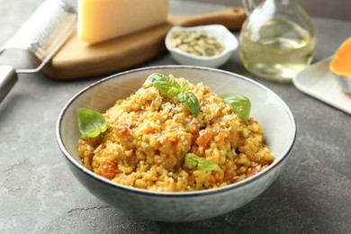 Photo of Delicious pumpkin risotto on grey table, closeup