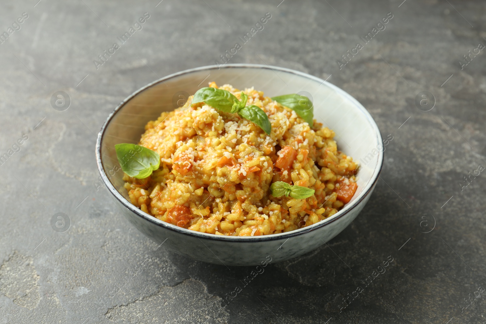 Photo of Delicious pumpkin risotto on grey table, closeup