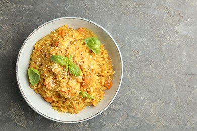 Photo of Delicious pumpkin risotto on grey table, top view. Space for text