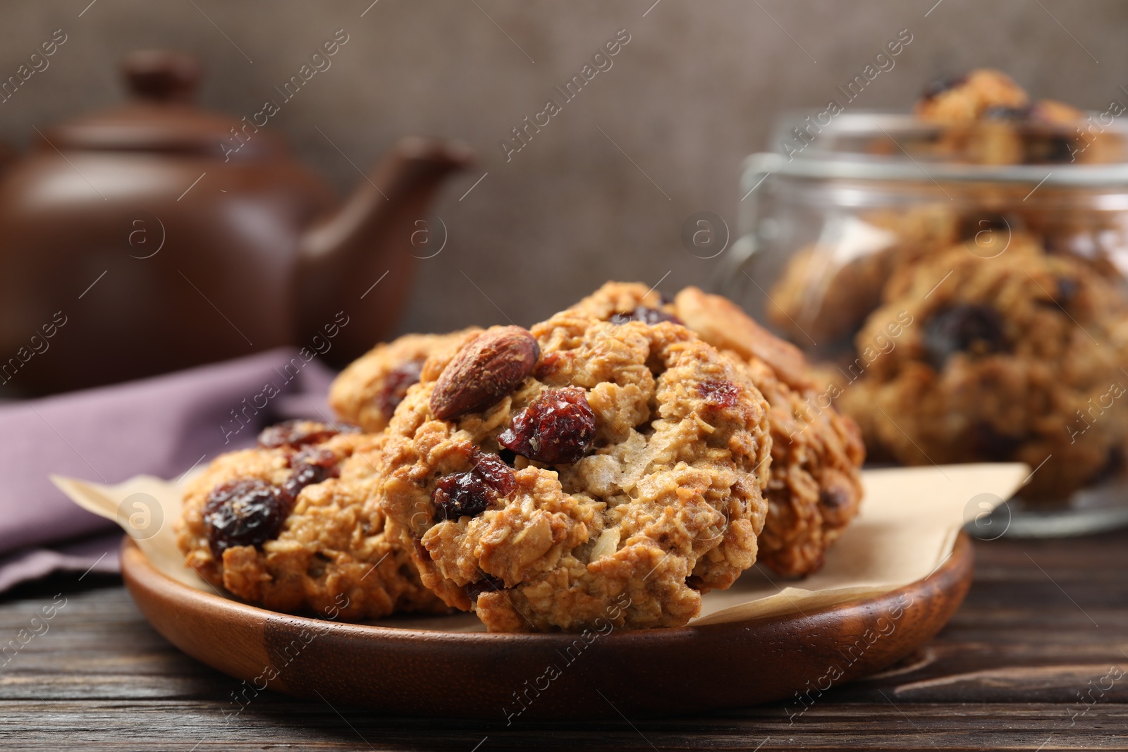 Photo of Delicious oatmeal cookies with raisins and nuts on wooden table, closeup