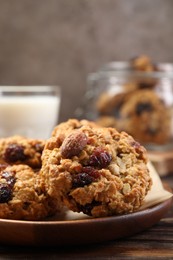 Delicious oatmeal cookies with raisins and nuts on wooden table, closeup