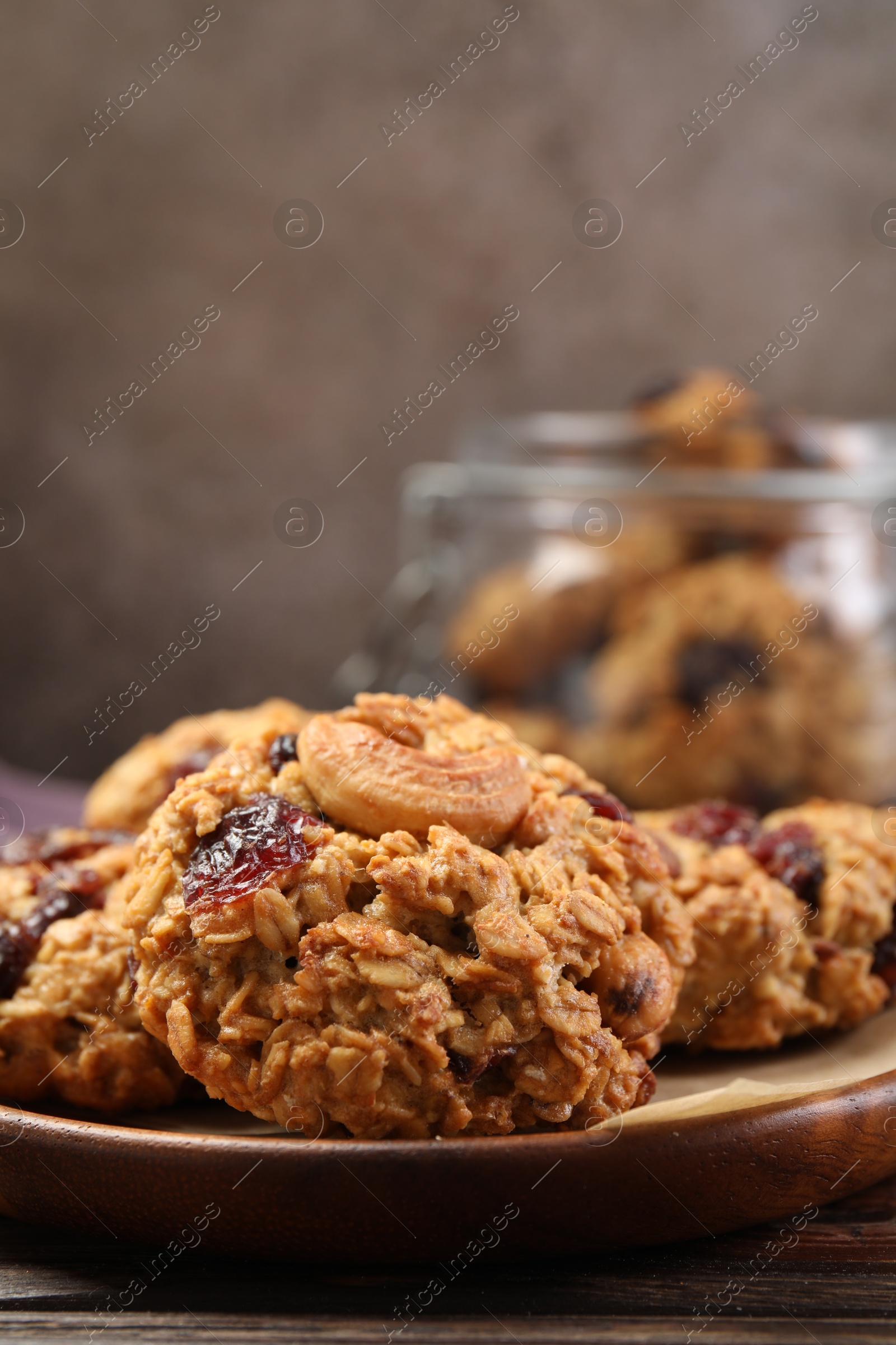 Photo of Delicious oatmeal cookies with raisins and nuts on wooden table, closeup