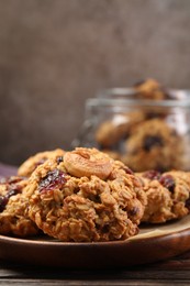 Photo of Delicious oatmeal cookies with raisins and nuts on wooden table, closeup