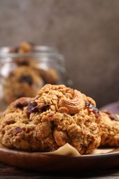 Photo of Delicious oatmeal cookies with raisins and nuts on wooden table, closeup