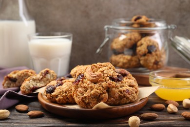 Delicious oatmeal cookies with raisins and nuts served on wooden table