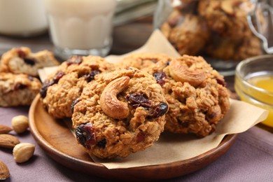 Photo of Delicious oatmeal cookies with raisins and nuts on table, closeup