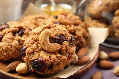 Photo of Delicious oatmeal cookies with raisins and nuts on table, closeup