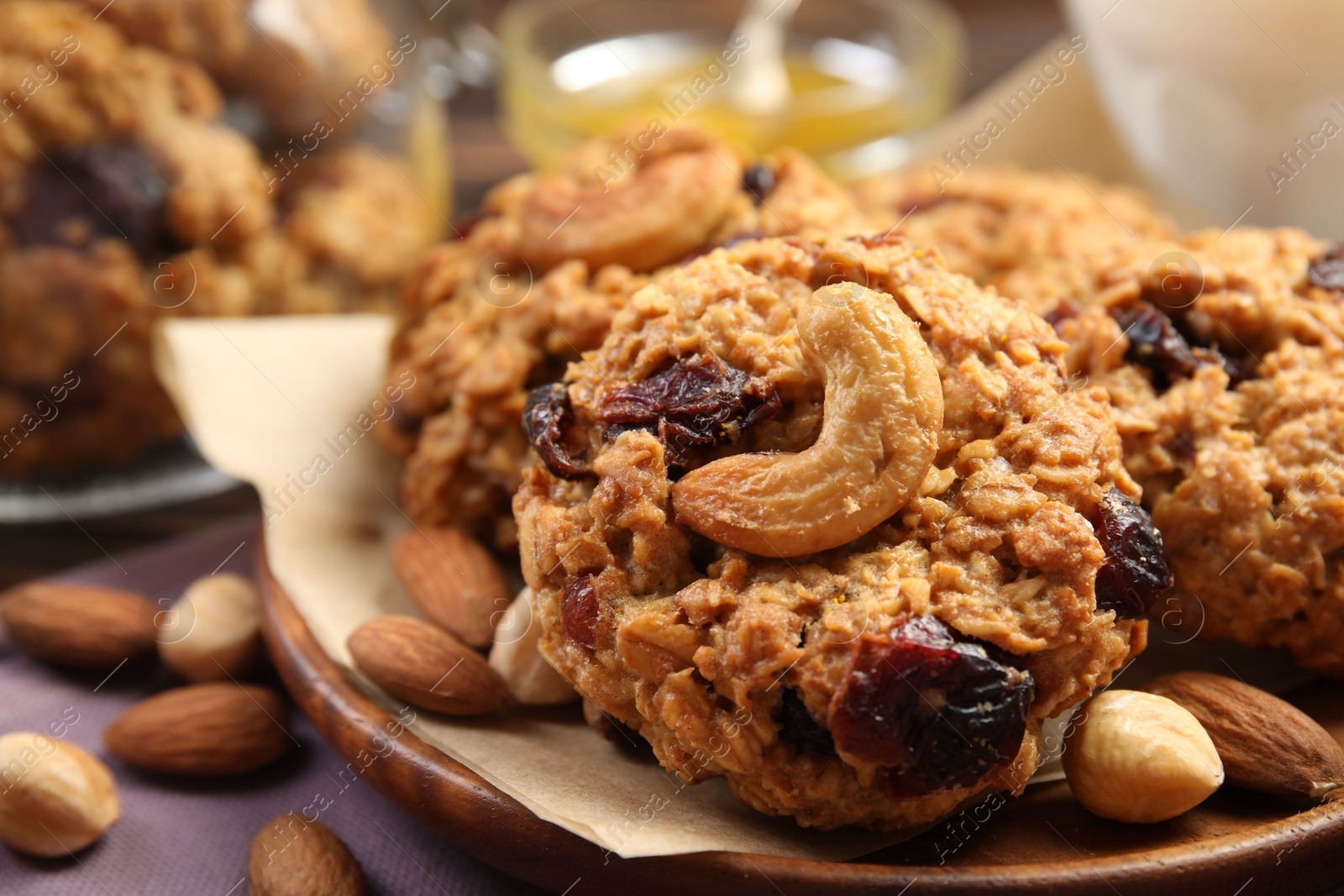 Photo of Delicious oatmeal cookies with raisins and nuts on table, closeup