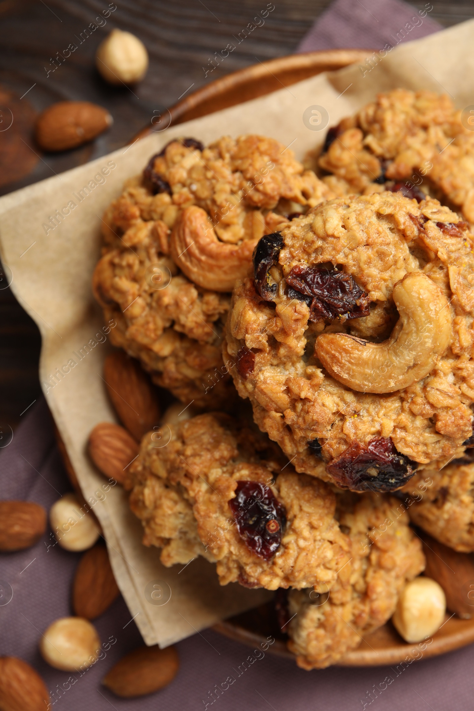 Photo of Delicious oatmeal cookies with raisins and nuts on wooden table, flat lay