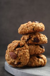 Photo of Delicious oatmeal cookies with raisins and nuts on grey table, closeup