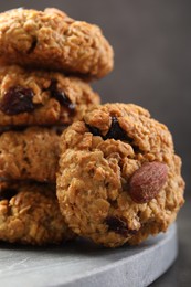 Photo of Delicious oatmeal cookies with raisins and nuts on grey table, closeup