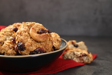 Photo of Delicious oatmeal cookies with raisins and nuts on grey table, closeup. Space for text