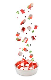 Image of Crab stick pieces, parsley and mix of peppers falling into bowl on white background