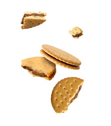 Image of Tasty broken sandwich cookies in air on white background