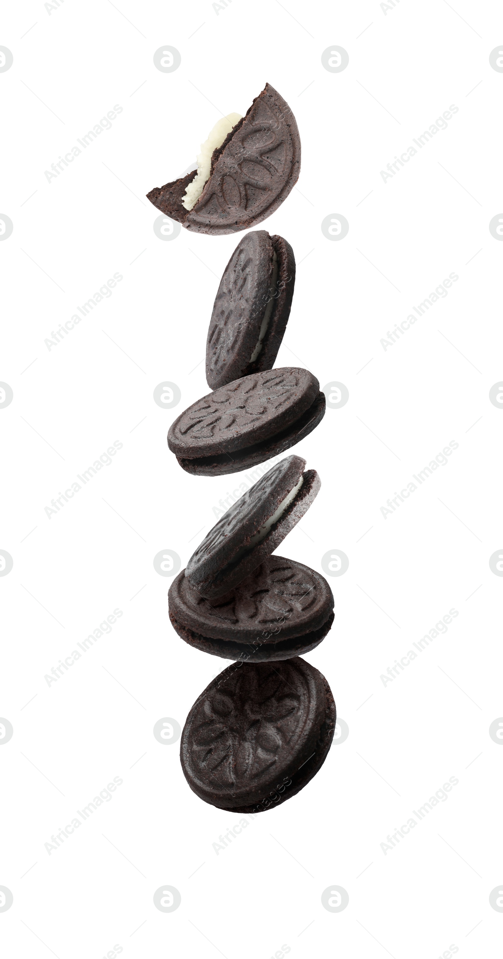 Image of Tasty broken sandwich cookies in air on white background