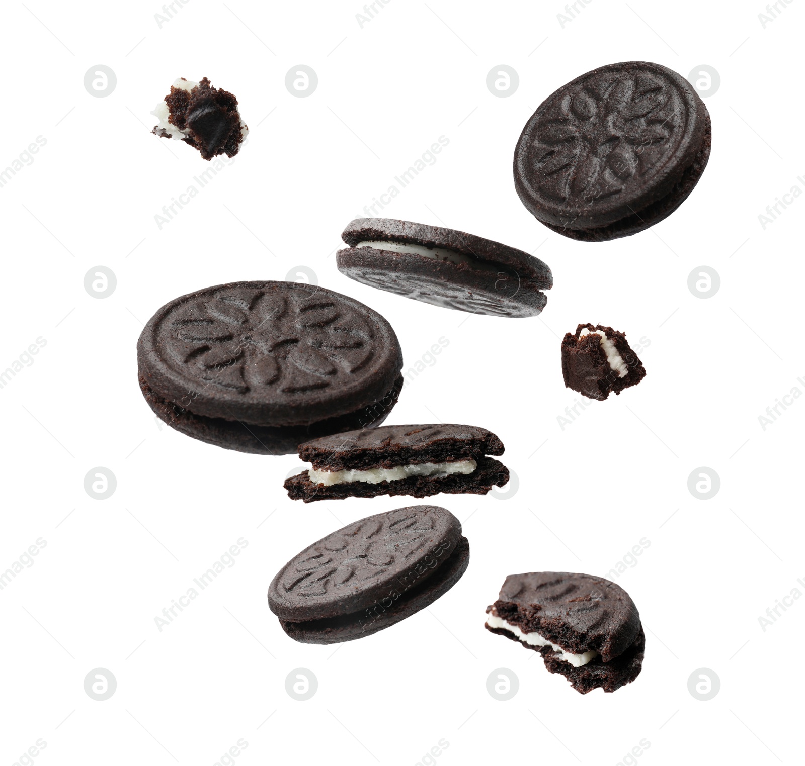 Image of Tasty broken sandwich cookies in air on white background