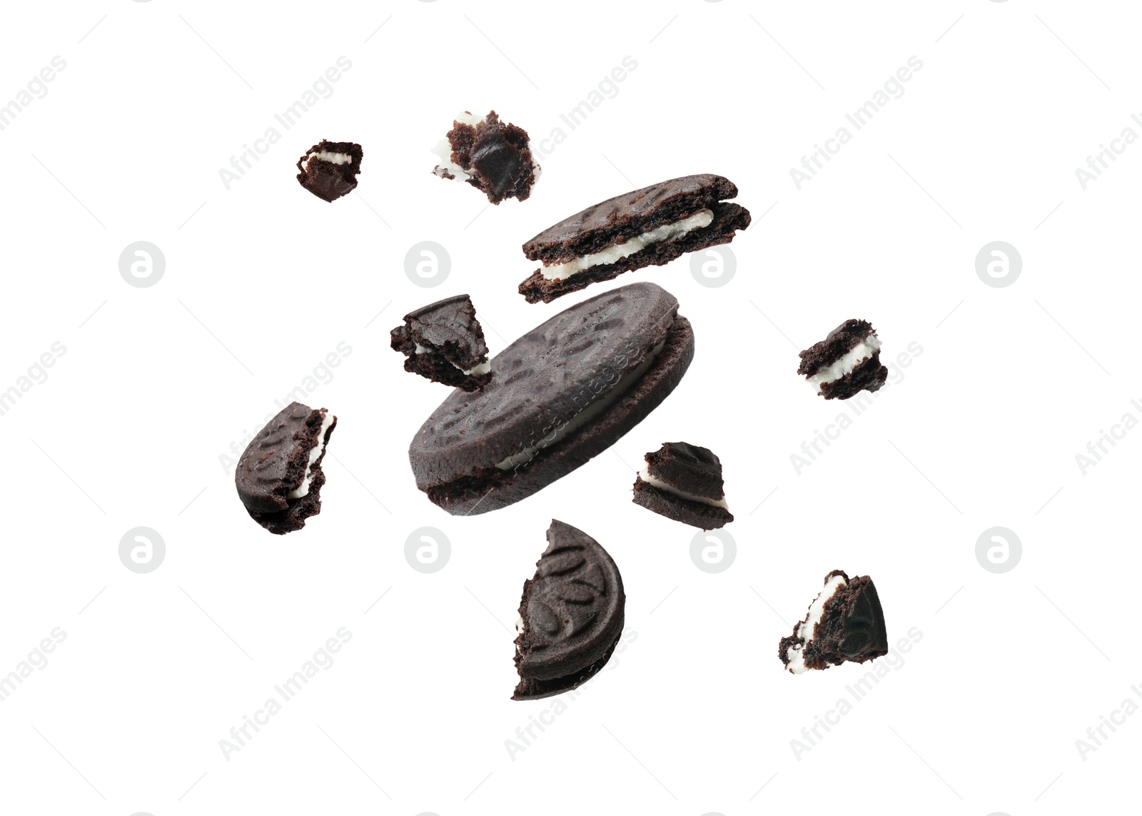 Image of Tasty broken sandwich cookies in air on white background