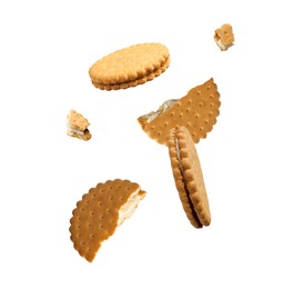 Image of Tasty broken sandwich cookies in air on white background