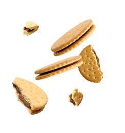 Image of Tasty broken sandwich cookies in air on white background