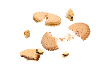 Image of Tasty broken sandwich cookies in air on white background