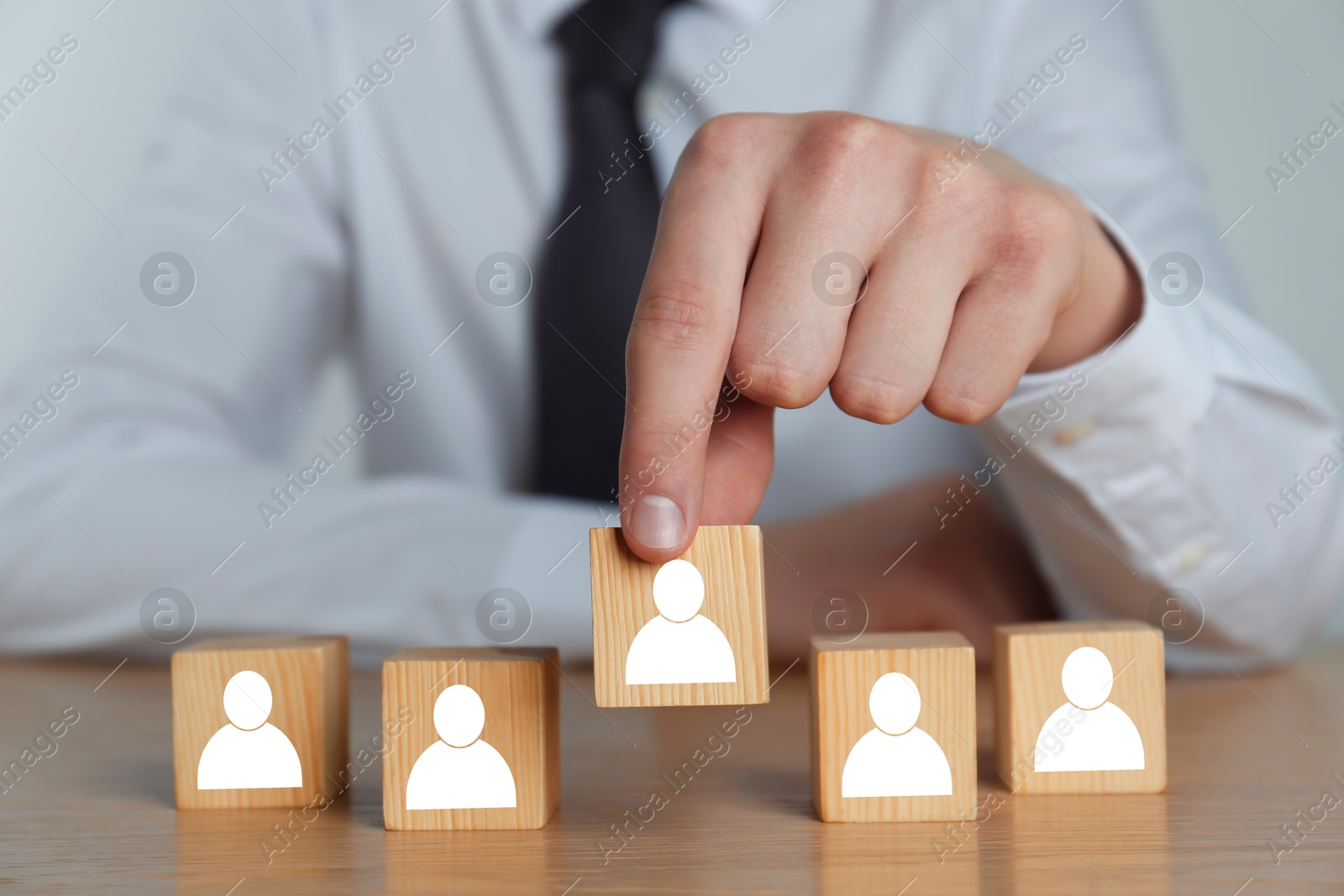 Image of Human resource. Man putting wooden cube with human icon in row of same others