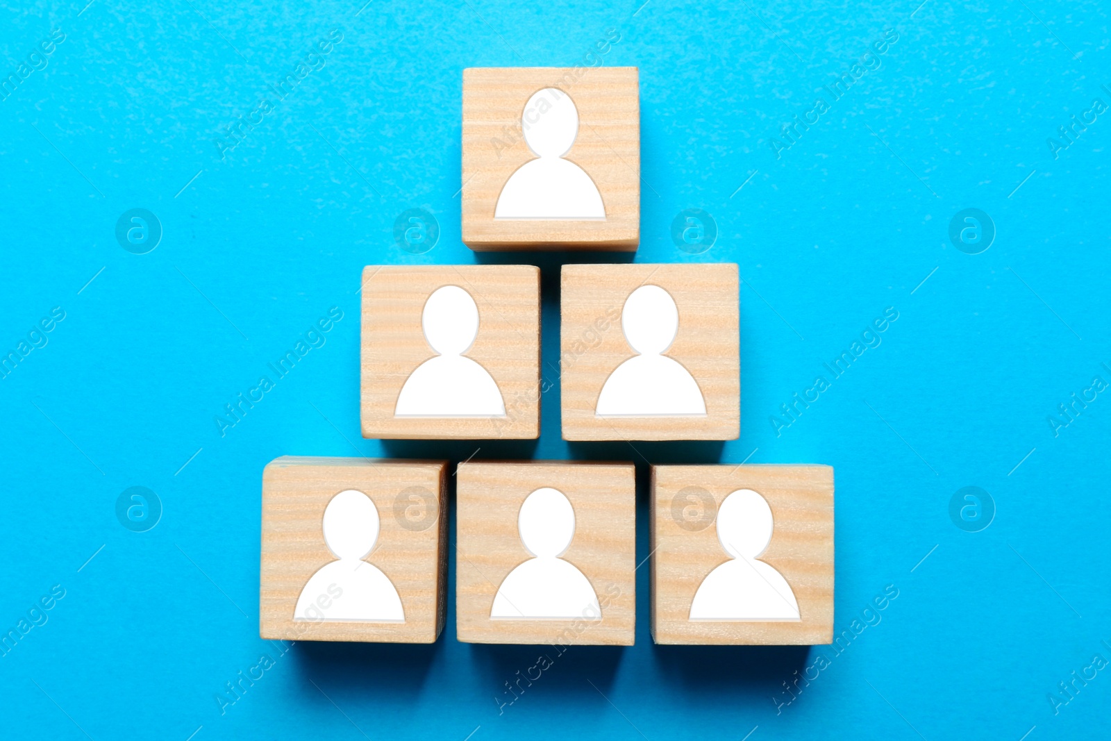 Image of Human resource. Pyramid of colorful cubes with human icons on light blue background, top view