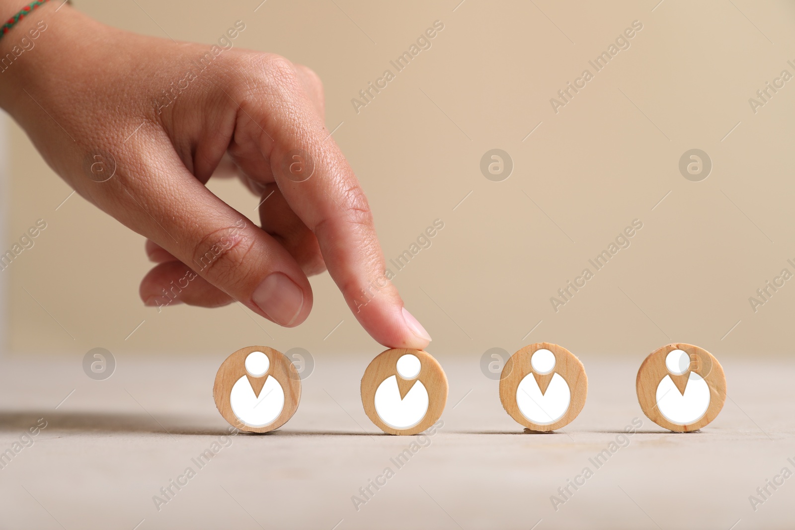 Image of Human resource. Woman touching one wooden circle with human icon among same others on table, closeup