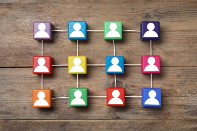 Image of Human resource. Scheme of colorful cubes with human icons on wooden background, top view