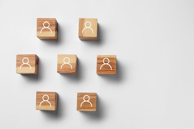 Image of Human resource. Wooden cubes with human icons on light grey background, top view