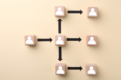 Human resource. Scheme of wooden cubes with human icons on beige background, top view