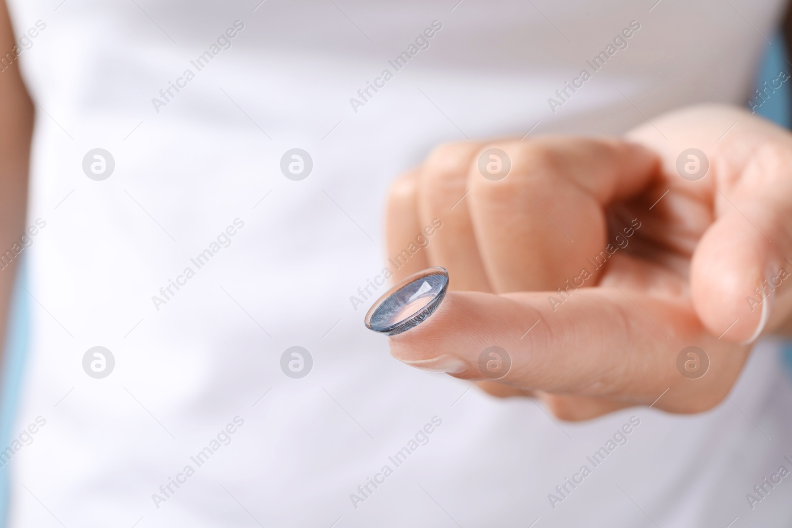 Photo of Woman holding color contact lens, closeup view