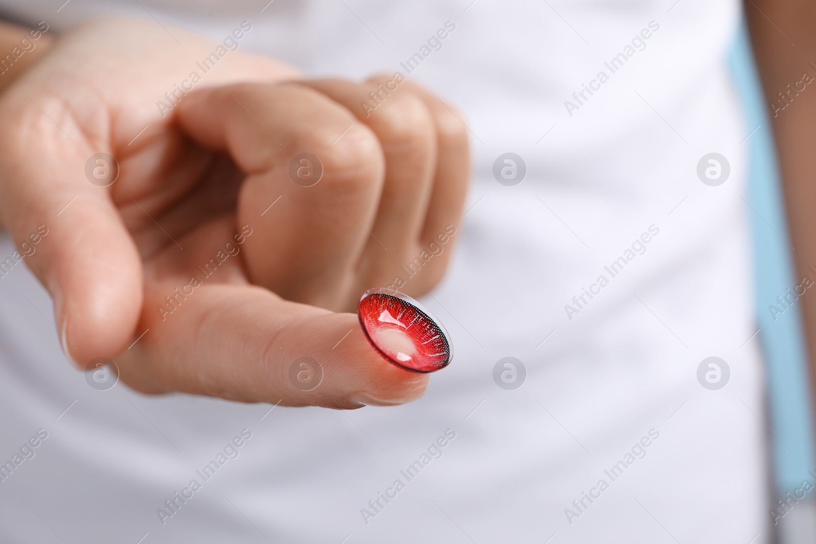 Photo of Woman holding color contact lens, closeup view