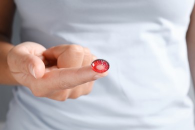 Photo of Woman holding one color contact lens, closeup