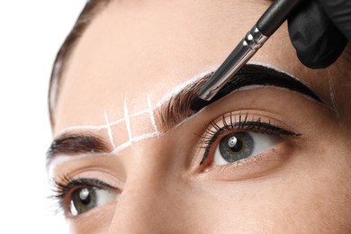 Photo of Young woman undergoing henna eyebrows dyeing on light background, closeup