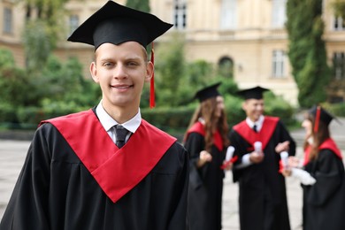 Graduation ceremony. Happy students outdoors, selective focus