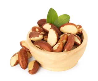 Photo of Tasty Brazil nuts and green leaves in bowl isolated on white