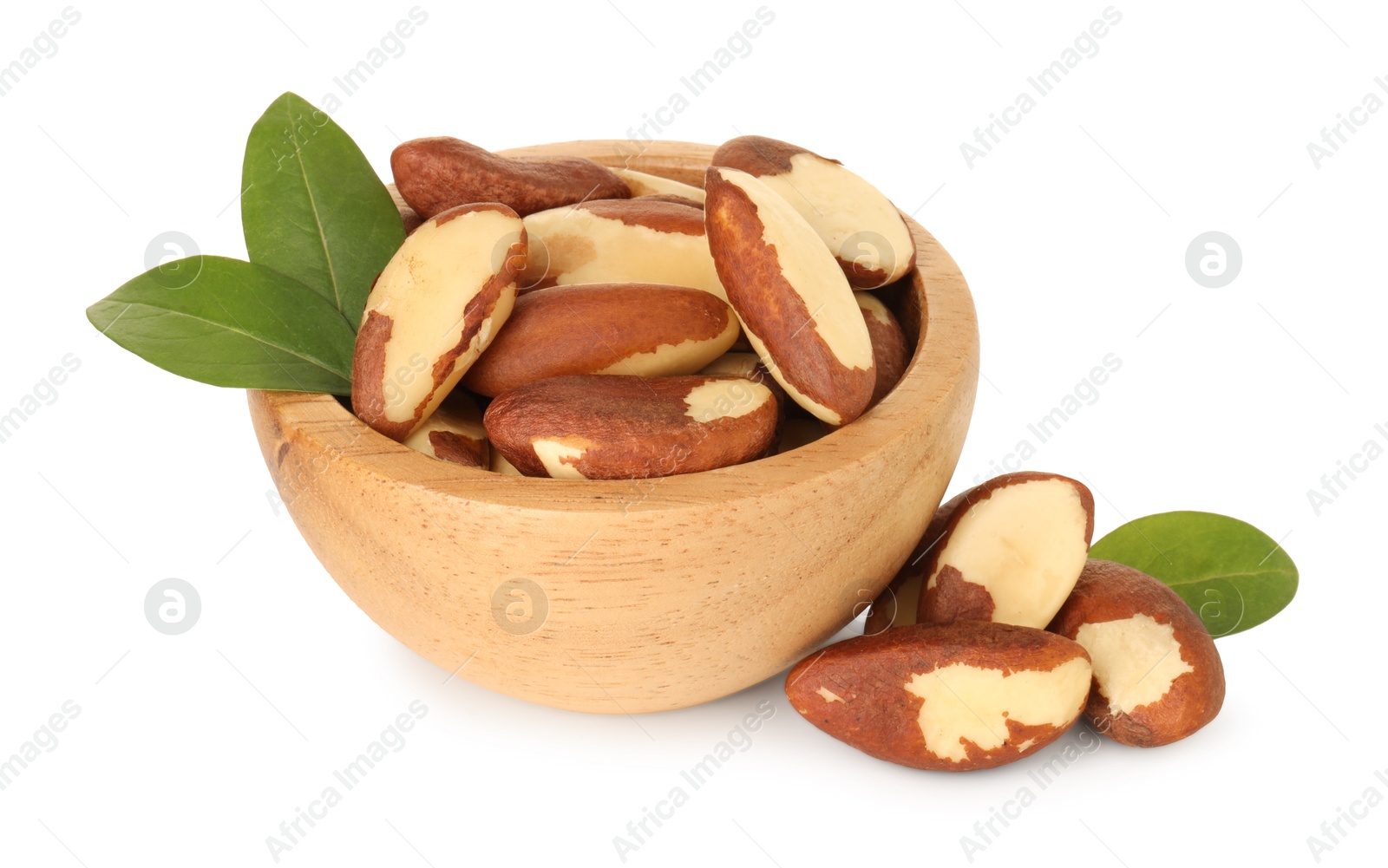 Photo of Tasty Brazil nuts in bowl and green leaves isolated on white