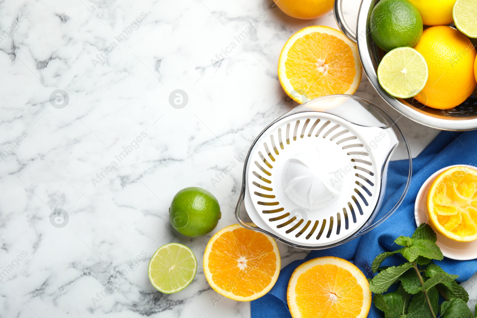 Photo of Plastic juicer and different citrus fruits on white marble table, flat lay. Space for text