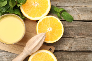 Photo of Juicer and fresh oranges on wooden table, flat lay