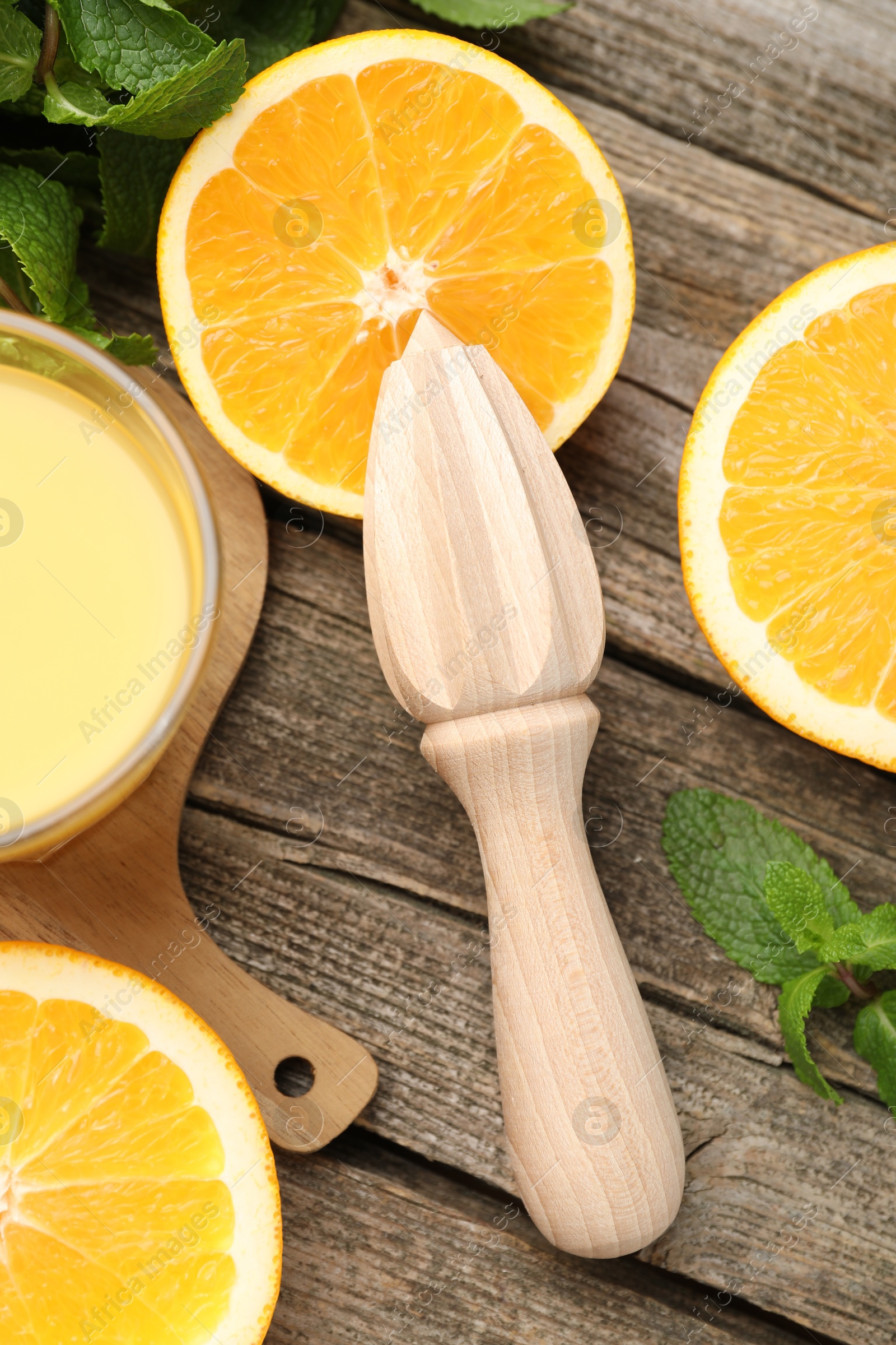 Photo of Juicer and fresh oranges on wooden table, flat lay