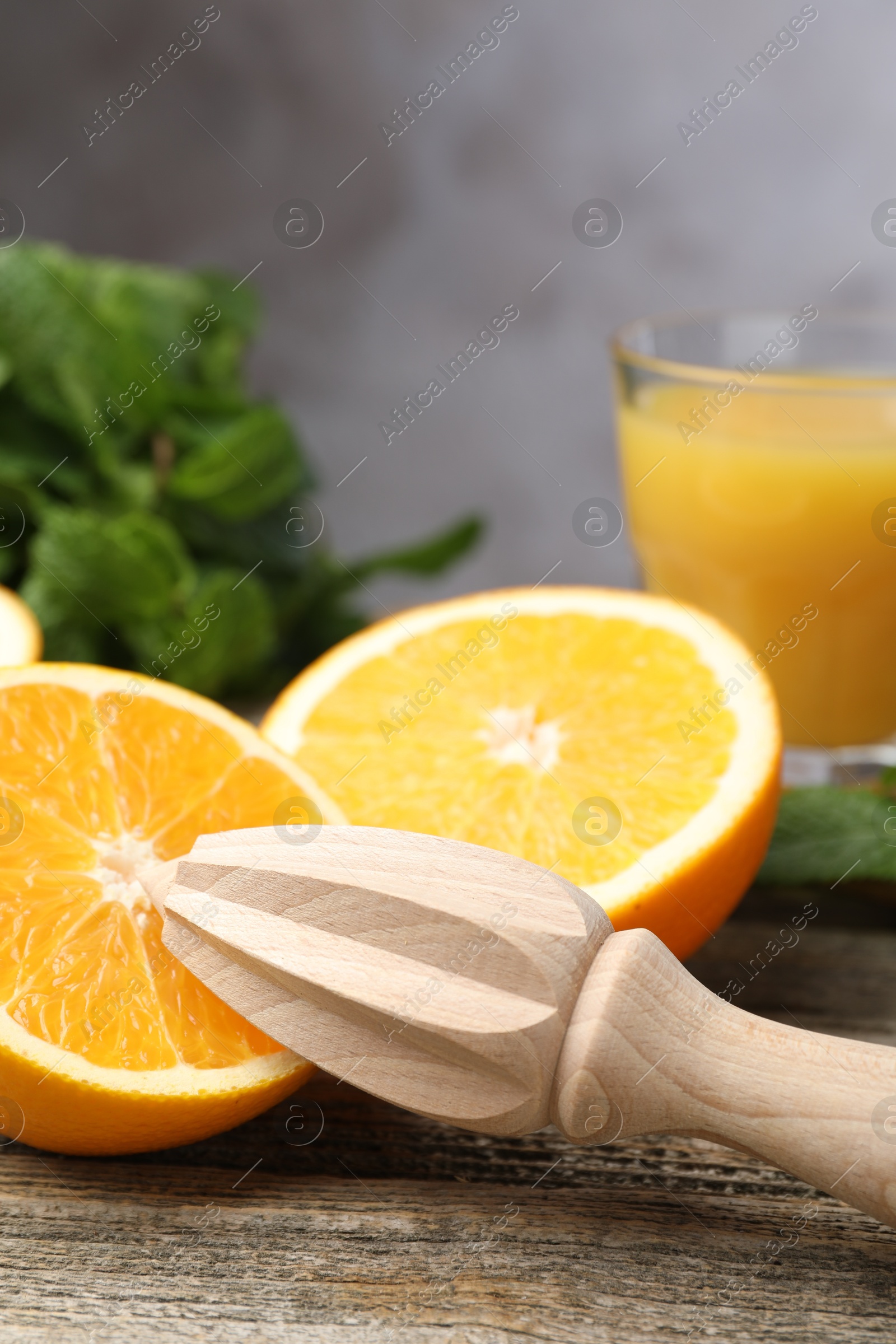 Photo of Juicer and fresh oranges on wooden table, closeup