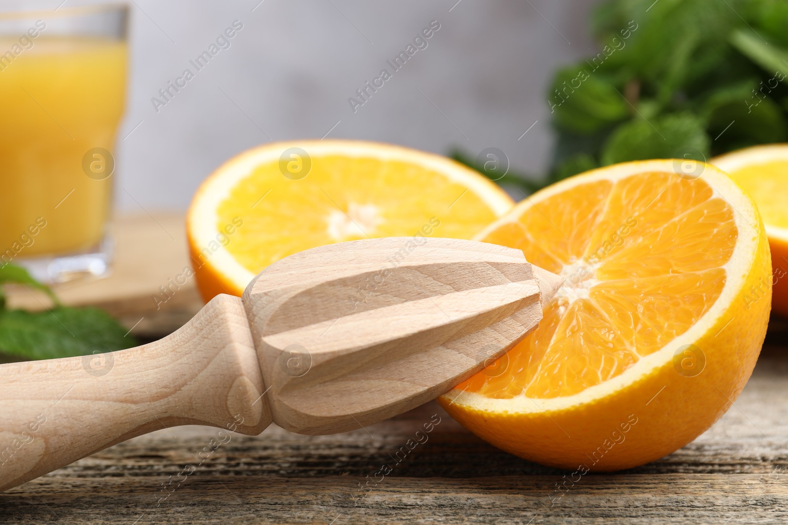 Photo of Juicer and fresh oranges on wooden table, closeup