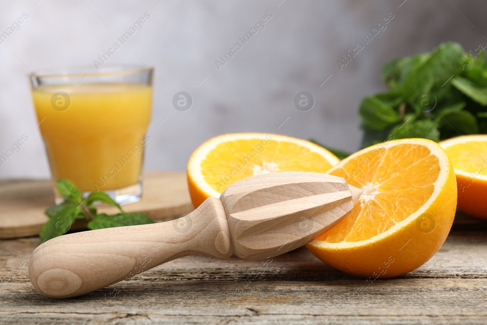 Photo of Juicer and fresh oranges on wooden table, closeup