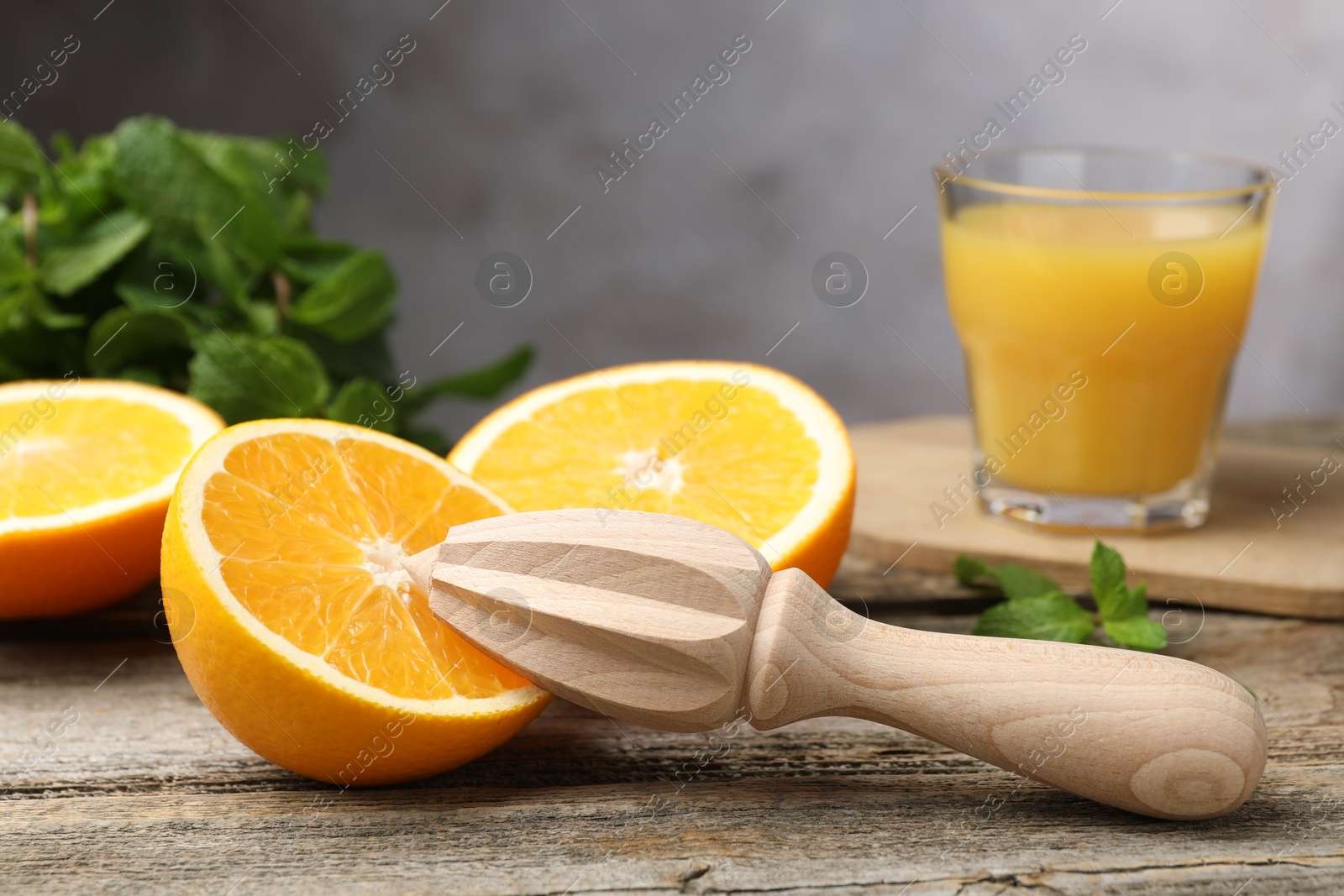 Photo of Juicer and fresh oranges on wooden table, closeup