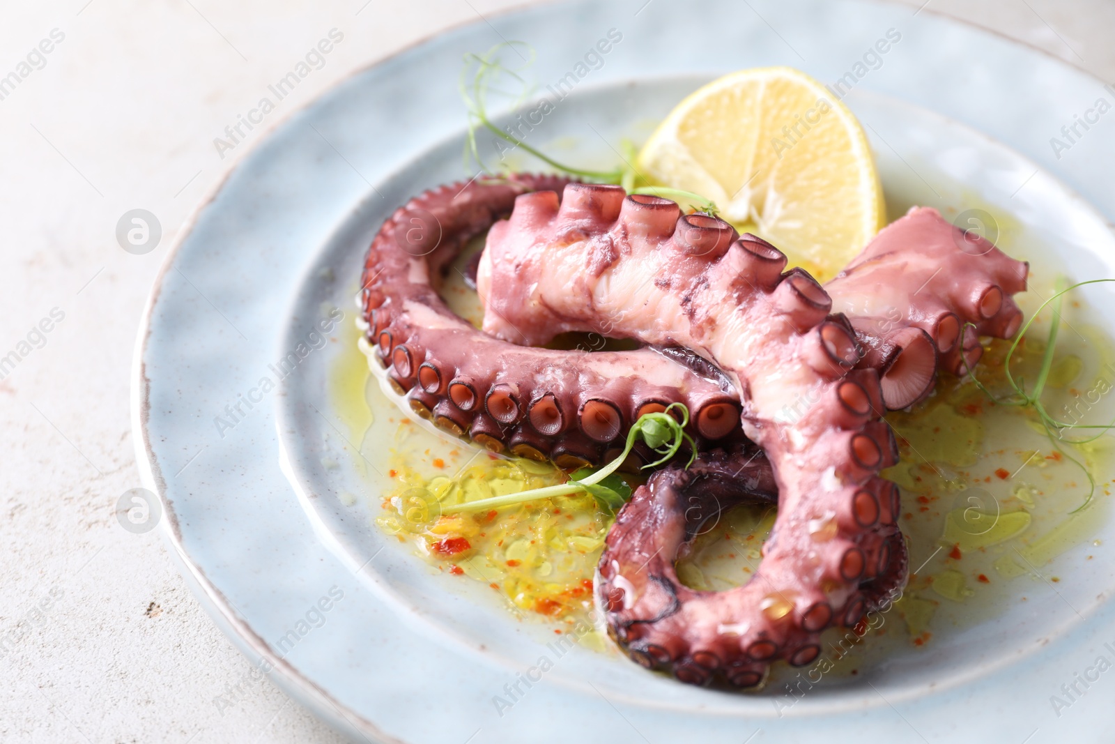 Photo of Appetizing octopus tentacles on light table, closeup